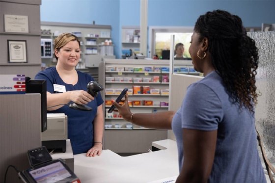 Picture of CVS customer getting a barcode on their phone scanned for a pharmacy pickup